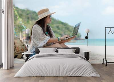 Lifestyle freelance woman using laptop working and relax on the beach.  Asian people success and together your work pastime and meeting conference on internet in holiday. Business and Summer Concept Wall mural